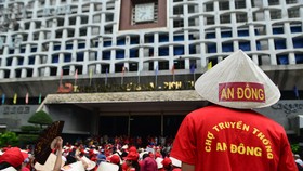 Hàng trăm người mặc đồng phục tập trung trước cổng chợ.