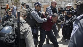 Cảnh sát Israel bắt giữ một người Palestine sau khi ông này kêu gọi các giáo sĩ cầu nguyện trên phố thay vì tại nhà thờ Hồi giáo Al Aqsa, tại thành phố cổ Jerusalem, ngày 19-7. Ảnh: AP