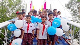 Học sinh ở huyện vùng lũ Hòn Đất (Kiên Giang) đến lớp trên cây cầu mới xây