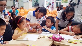 Các thành viên CLB Blouse Xanh hướng dẫn các bệnh nhi tô màu, vẽ tranh tại chương trình Mùa hè tuổi thơ 2017.