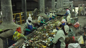 Workers sort waste at a waste treatment factory (Photo: VNA)