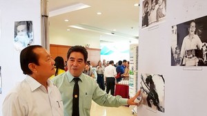 Former Secretary of the municipal Party Committee Le Thanh Hai (L) enjoys pictures in the exhibition. (Photo: Sggp)