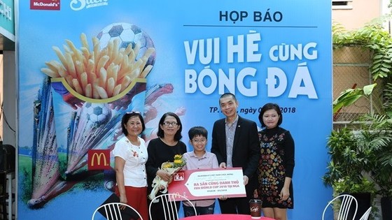 The organising board awards the ticket to Nguyễn Lê Thanh Sơn (middle) (Photo cand.com.vn)