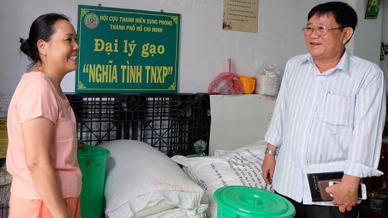 Ông Tống Văn Lường thăm hỏi và hướng dẫn cho đồng đội tại đại lý gạo “Nghĩa tình TNXP” quận Tân Bình