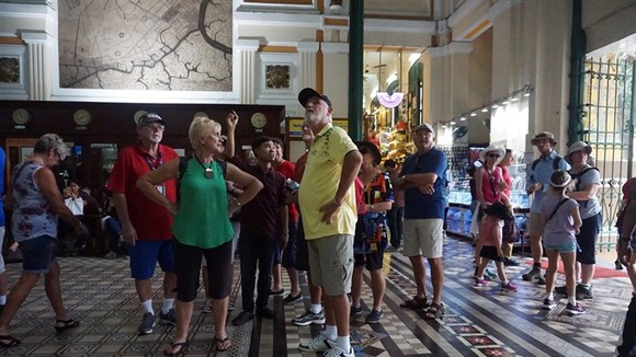 A tour guide with a group of tourists at the Central Post Office in HCM City. Photo: VNS