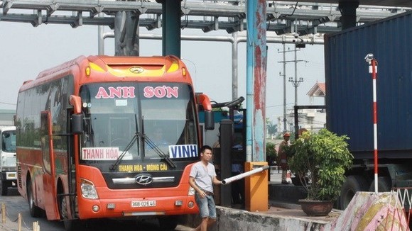 Tài xế tự nhấc barie để đi tại trạm thu phí BOT cầu Tân Đệ. (Ảnh: Thế Duyệt/TTXVN)