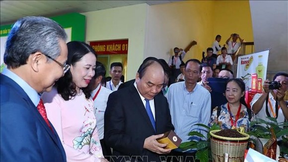 Prime Minister Nguyen Xuan Phuc visits an exhibition within the conference. (Photo: VNA)