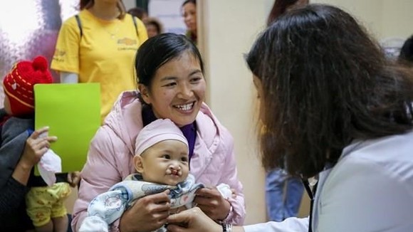A baby with cleft palates receives examination (Photo: VNA)