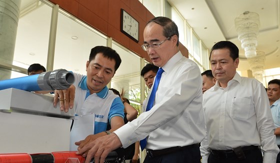 HCMC Party Chief Nguyen Thien Nhan learns about Vietnamese branded products (Photo: SGGP)