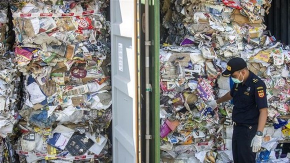 An Indonesian customs official inspects containers of waste sent from Australia (Photo: AFP/VNA)