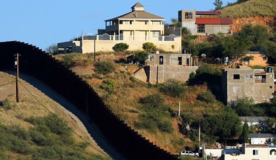 Tường rào biên giới giữa 2 TP Nogales: Nogales ở bang Sonora của Mexico (phải) và Nogales ở bang Arizona của Mỹ. Ảnh: REUTERS
