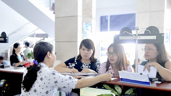 Doanh nghiệp nghe nhân viên Cục thuế TPHCM hướng dẫn làm hồ sơ. Ảnh: CAO THĂNG