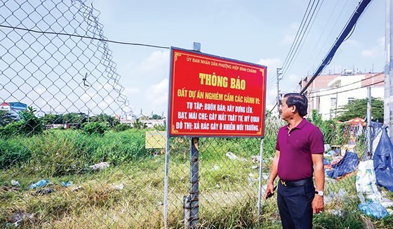 Ông Ngô Mạnh Hân bên cạnh mảnh đất của mình bị treo quyền lợi suốt 27 năm qua. Ảnh: M.TUẤN