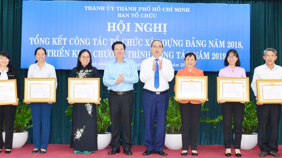 Bí thư Thành ủy TPHCM Nguyễn Thiện Nhân và Phó Trưởng Ban Tổ chức Trung ương Mai Văn Chính, chúc mừng các tập thể được nhận bằng khen. Ảnh: KIỀU PHONG