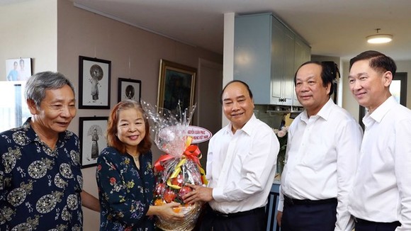 Prime Minister Nguyen Xuan Phuc (centre) presents a gift to former Chairwoman of the HCM City Journalists Association Nguyen Thi Hang Nga (second, left) on June 18 (Photo: VNA)