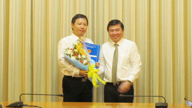 Chủ tịch UBND TPHCM Nguyễn Thành Phong (phải) trao quyết định và tặng hoa chúc mừng đồng chí Dương Anh Đức, Giám đốc Sở Thông tin và Truyền thông.