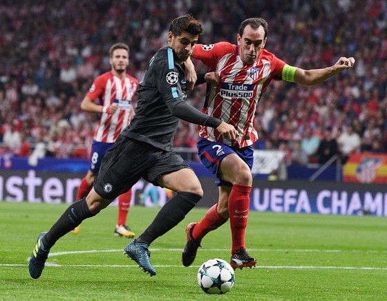 Alvaro Morata (trái, Chelsea) đi bóng qua Diego Godin (Atletico Madrid). Anh: Getty Images.