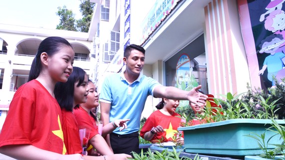 Thầy Lưu Hoàng Phúc hướng dẫn HS cách trồng và chăm sóc rau củ quả tại vườn ươm của trường