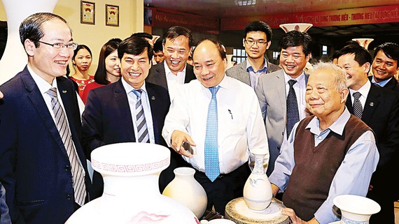 Thủ tướng Nguyễn Xuân Phúc đến thăm công ty cổ phần gốm Chu Đậu. Ảnh: TTXVN
