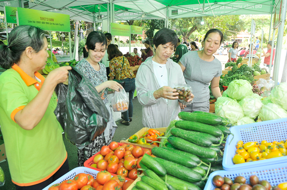 Người dân mua nông sản an toàn tại một chợ phiên. Ảnh: CAO THĂNG