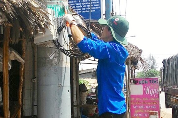 Thanh niên công nhân điện lực tham gia xóa lưới tạp  để đảm bảo an toàn điện mùa mưa tại huyện Bình Chánh