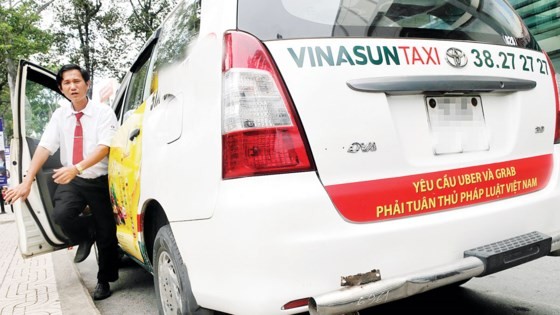 Taxi firms required to stop hanging Uber, Grab protest banners ảnh 1