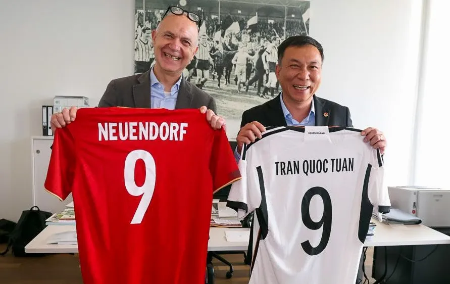 Ông Trần Quốc Tuấn và ông Bernd Neuendorf trao tặng cho nhau áo thi đấu của đội tuyển hai nước