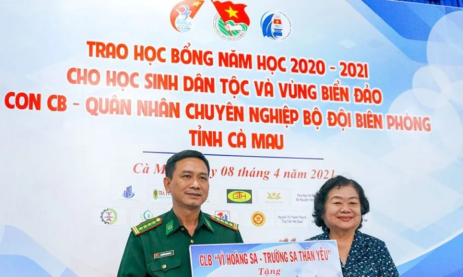 Đại tá Nguyễn Quang Hà, Phó Chính ủy Bộ Chỉ huy Bộ đội Biên phòng tỉnh Cà Mau nhận bảng tượng trưng 100 suất học bổng trị giá 100 triệu đồng do bà Trương Mỹ Hoa trao tặng. Ảnh: BĂNG THANH