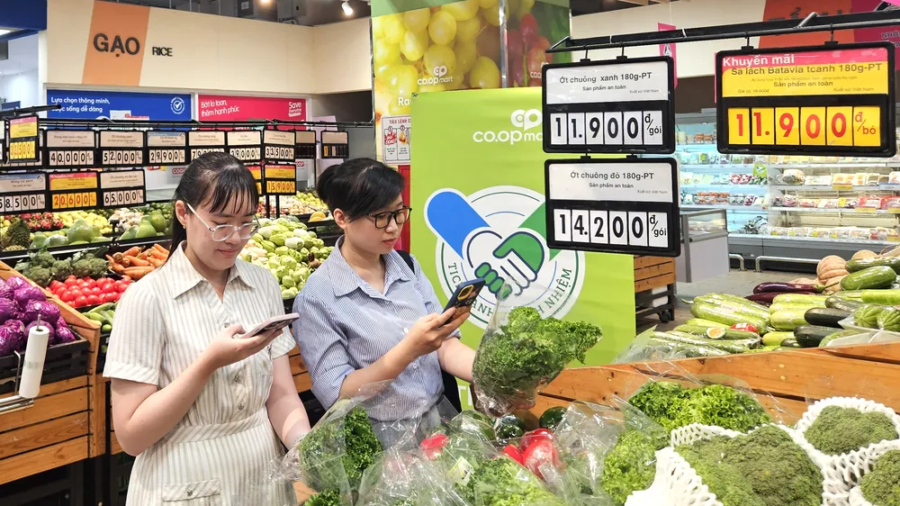 Khách hàng kiểm tra thông tin sản phẩm "Tick xanh trách nhiệm" tại một siêu thị Co.opmart, TPHCM (ẢNH: PHƯƠNG NHI)