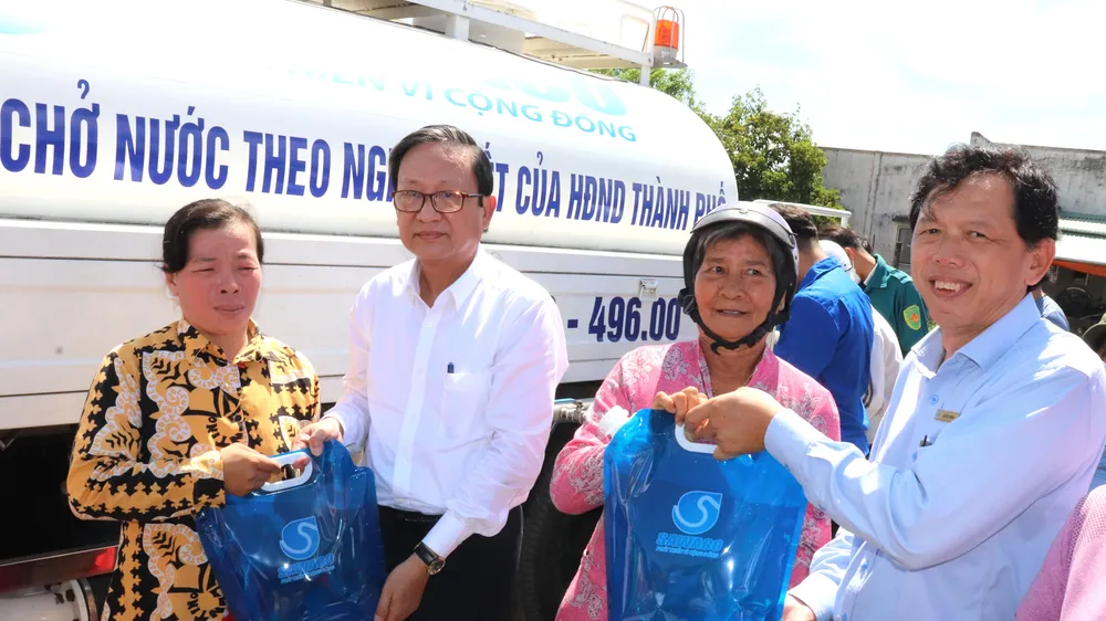  Ông Nguyễn Thanh Sử (thứ 2 bên trái), Phó Tổng giám đốc SAWACO, trao tặng túi nước sạch đến người dân xã Phú Đông, huyện Tân Phú Đông (tỉnh Tiền Giang)
