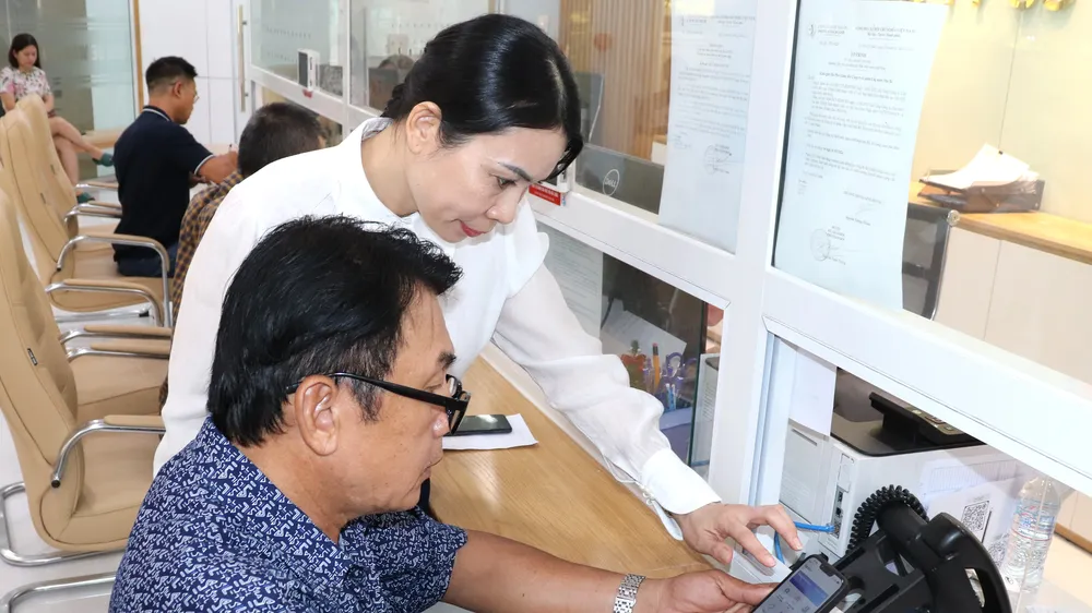 Nhân viên Công ty CP Cấp nước Nhà Bè hướng dẫn người dân thực hiện các giao dịch trên môi trường số