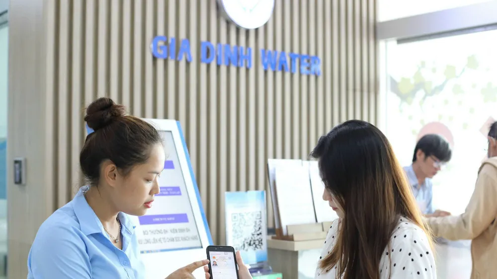 Nhân viên Công ty CP Cấp nước Gia Định hướng dẫn khách hàng thực hiện các giao dịch cấp nước trên môi trường số