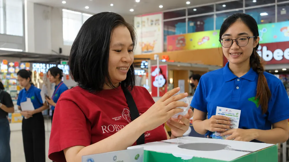 Khách hàng đổi quà sau khi được hướng dẫn sử dụng E-voucher (ẢNH: HOÀNG MAI)
