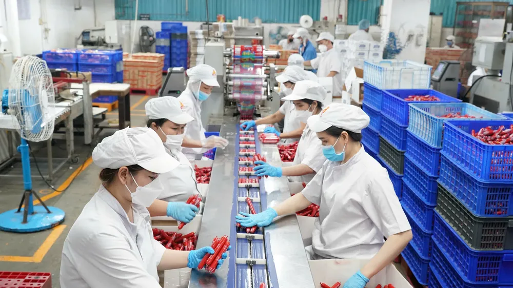 Công nhân vận hành dây chuyền chế biến thực phẩm tại Công ty Vissan, TPHCM (ẢNH: HOÀNG HÙNG)