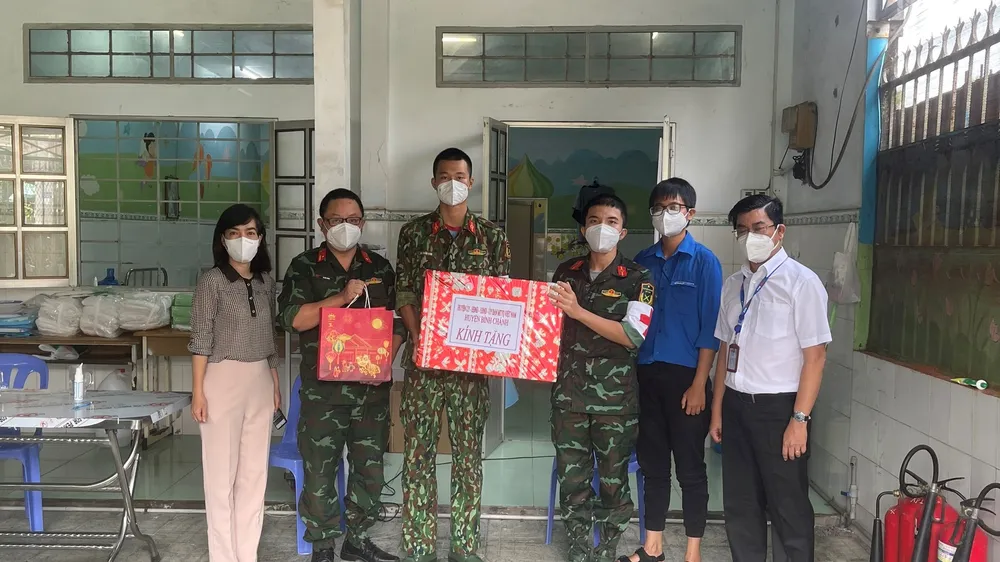  Phó Bí thư Thường trực Đảng ủy Tổng Công ty Điện lực TPHCM Bùi Hải Thành (bìa phải) thăm và tặng quà các y bác sĩ, nhân viên Trạm y tế lưu động số 12 tại xã Đa Phước, huyện Bình Chánh