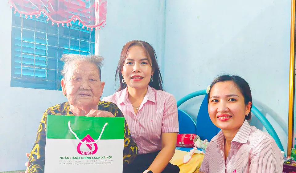 Bà Trịnh Bích Tuyền, Phó Giám đốc phụ trách Ngân hàng Chính sách xã hội Chi nhánh tỉnh Sóc Trăng (giữa) tặng quà cho gia đình chính sách