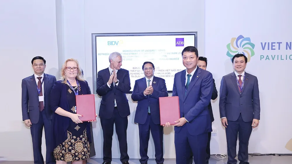 Ông Lê Ngọc Lâm, Tổng Giám đốc BIDV và bà Suzanne Gaboury, Vụ trưởng Vụ Nghiệp vụ khu vực tư nhân của ADB trao Bản ghi nhớ hợp tác về thúc đẩy tín dụng xanh, tài chính bền vững