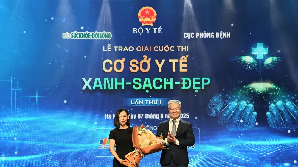 Nhà báo Trần Tuấn Linh, Tổng Biên tập Báo Sức khỏe và Đời sống tặng hoa bà Nguyễn Bạch Điệp, Chủ tịch FPT Retail kiêm Tổng Giám đốc Hệ thống nhà thuốc và tiêm chủng Long Châu - đại diện Nhà tài trợ cuộc thi
