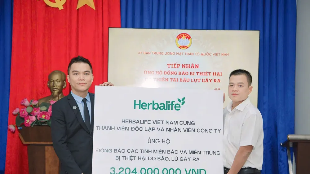 Đại diện Herbalife Việt Nam Ông Nguyễn Thành Đạt, Giám Đốc Truyền Thông (áo west đen) trao tiếp nhận ủng hộ cho Ông Nguyễn Hải Nam