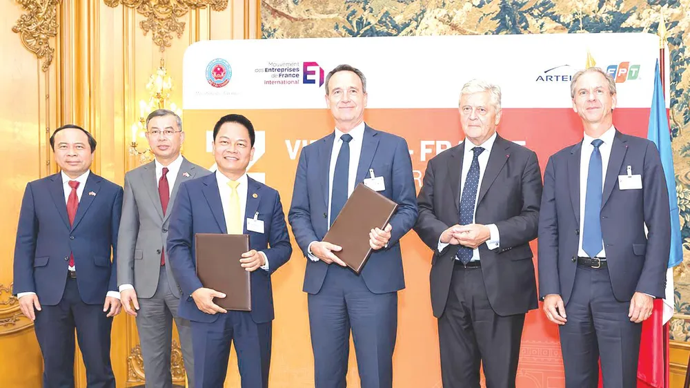 Ông Nguyễn Ngọc Nghị, Phó Tổng Giám đốc T&T Group, Chủ tịch T&T Energy Group và ông Arnaud Lenail Chouteau, Phó Chủ tịch cấp cao kiêm Tổng Giám đốc TotalEnergies Gas & Power Activities trao biên bản ghi nhớ về hợp tác phát triển Dự án điện khí LNG Long Sơn (ẢNH: ANH CHIẾN)