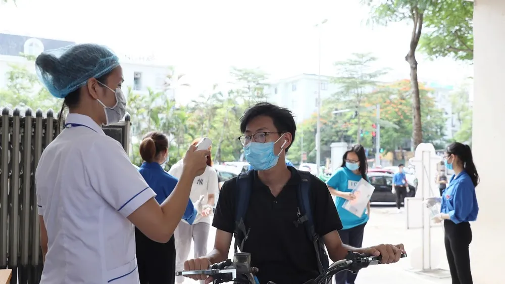 Đo thân nhiệt cho thí sinh. Ảnh: QUANG PHÚC 