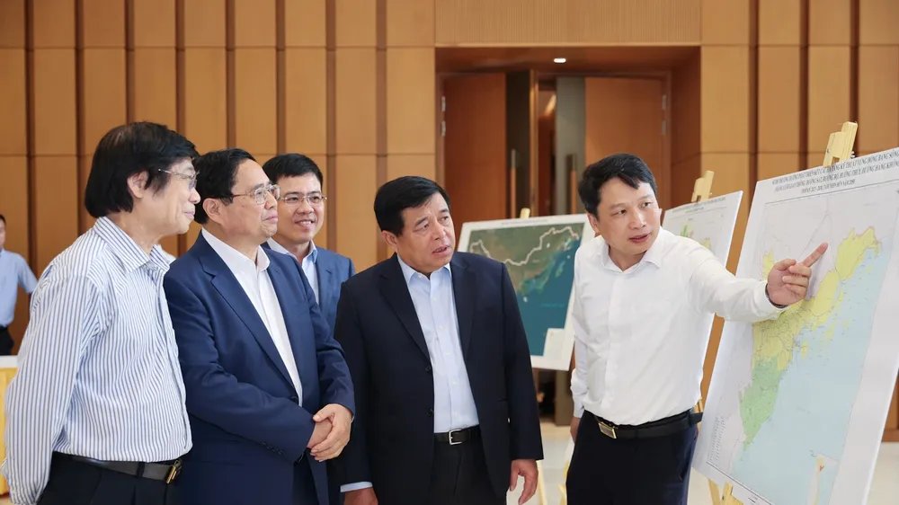 Thủ tướng Phạm Minh Chính và các đại biểu xem giới thiệu sơ đồ quy hoạch vùng Đồng bằng sông Hồng. Ảnh: VIẾT CHUNG