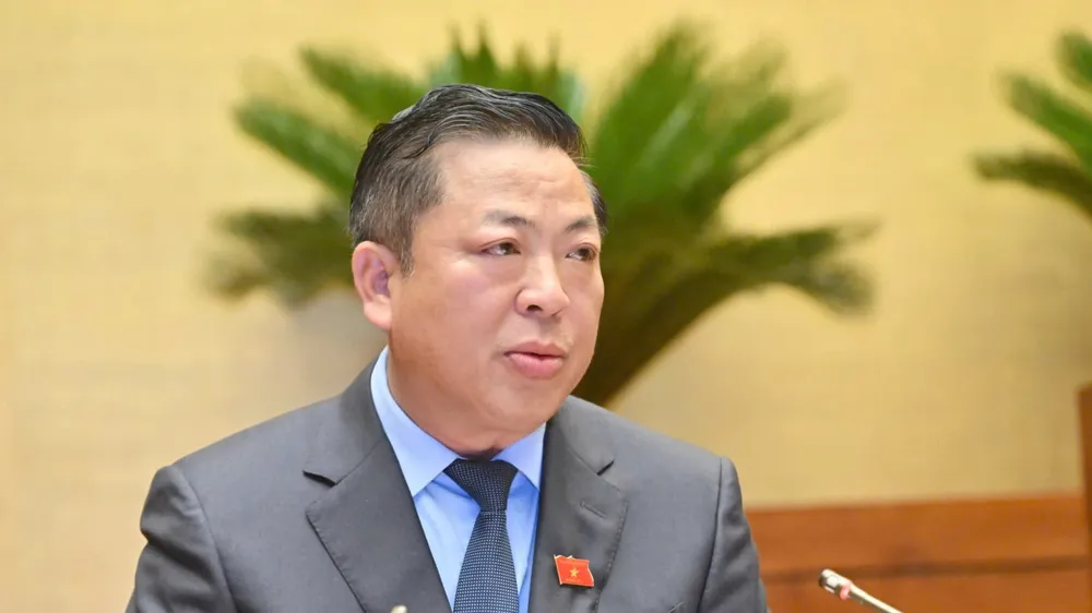 Bộ trưởng Bộ Xây dựng Trần Hồng Minh trình bày tờ trình, sáng 19-5. Ảnh: VIẾT CHUNG