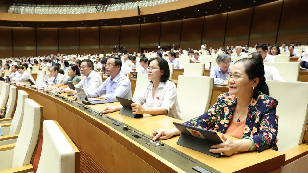Đại biểu Quốc hội bấm nút biểu quyết thông qua luật. Ảnh: QUANG PHÚC