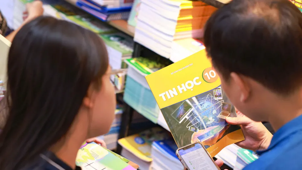 Nhiều ngày qua, phụ huynh chạy đôn chạy đáo các nhà sách để mua sách giáo khoa cho con. Ảnh: NGỌC THỦY