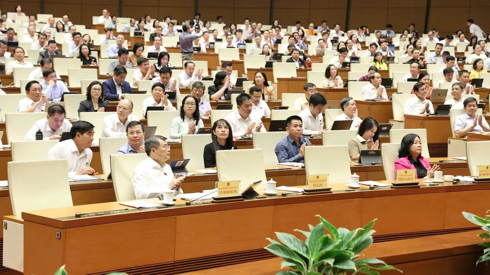 Thủ tướng Lê Minh Hưng và các đại biểu tán thành Quốc hội thông qua các luật sáng 24-8. Ảnh QUANG PHÚC