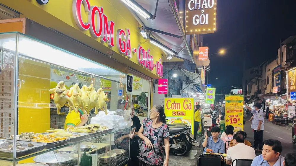 Khách thưởng thức cơm gà, cháo gà các loại tối 21-12 tại tuyến phố ẩm thực Nguyễn Thượng Hiền