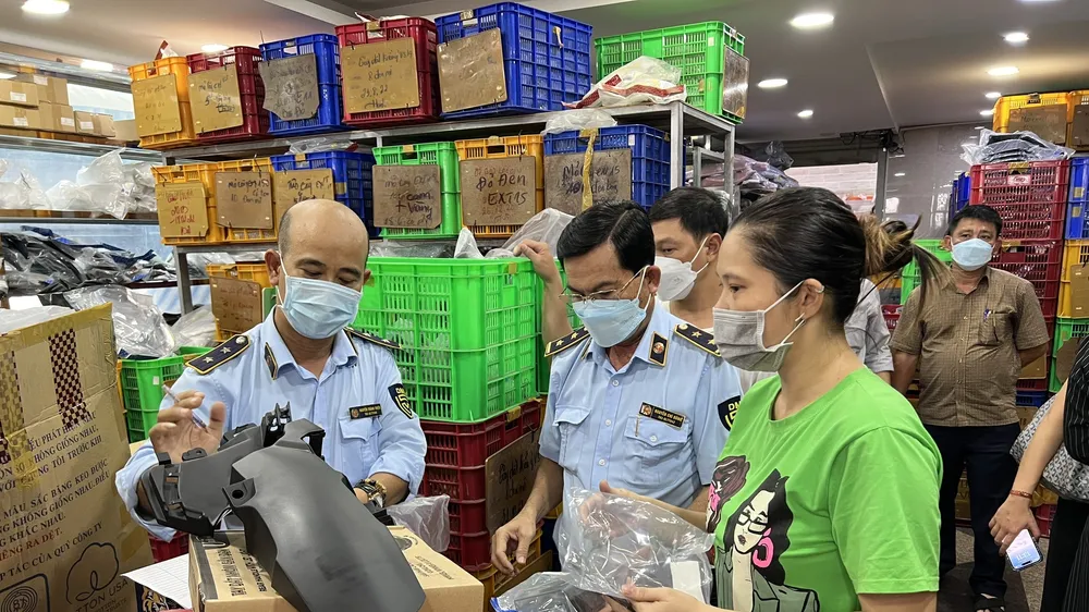 Quản lý thị trường kiểm tra hàng hóa và làm việc với đại diện một cửa hàng tại chợ Tân Thành 