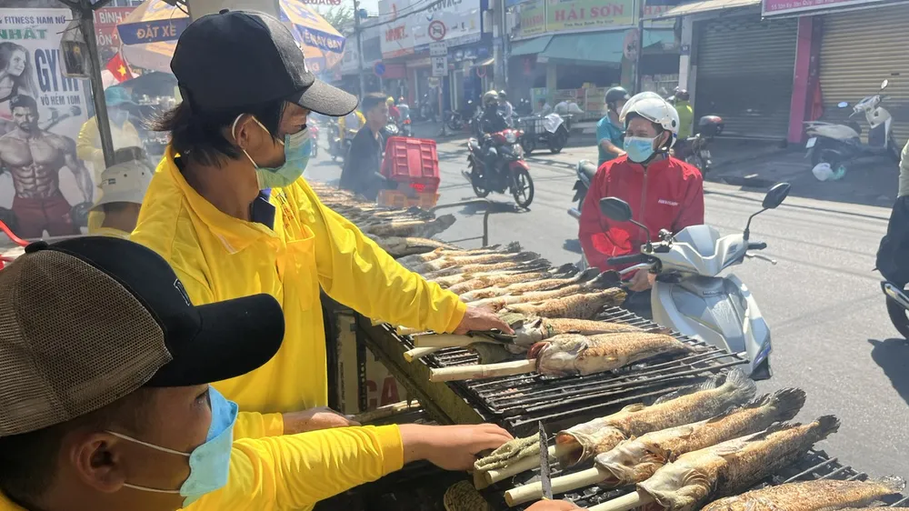Cá lóc nướng mía thơm phức trên đường Tân Kỳ Tân Quý trưa 18-2. Ảnh: THI HỒNG
