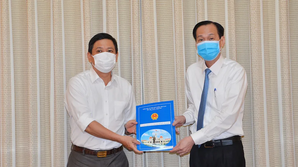 Phó Chủ tịch Thường trực UBND TPHCM Lê Thanh Liêm trao quyết định của UBND TPHCM về điều động đồng chí Trần Xuân Điền, Chủ tịch UBND quận 10, đến nhận công tác tại Thành ủy TPHCM. Ảnh: VIỆT DŨNG